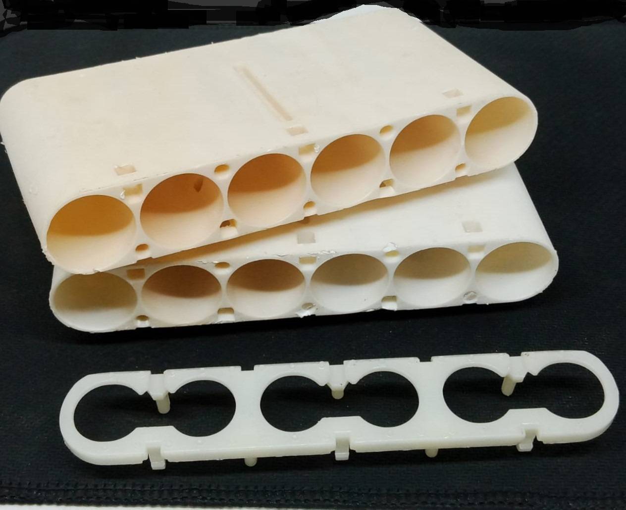 20700A Cell Holder dyson - two white plastic battery housing blocks with five circular slots each and one matching flat spacer plate.