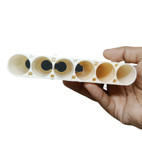 20700A Cell Holder dyson - a cream-colored plastic bracket with six cylindrical slots held in a hand.