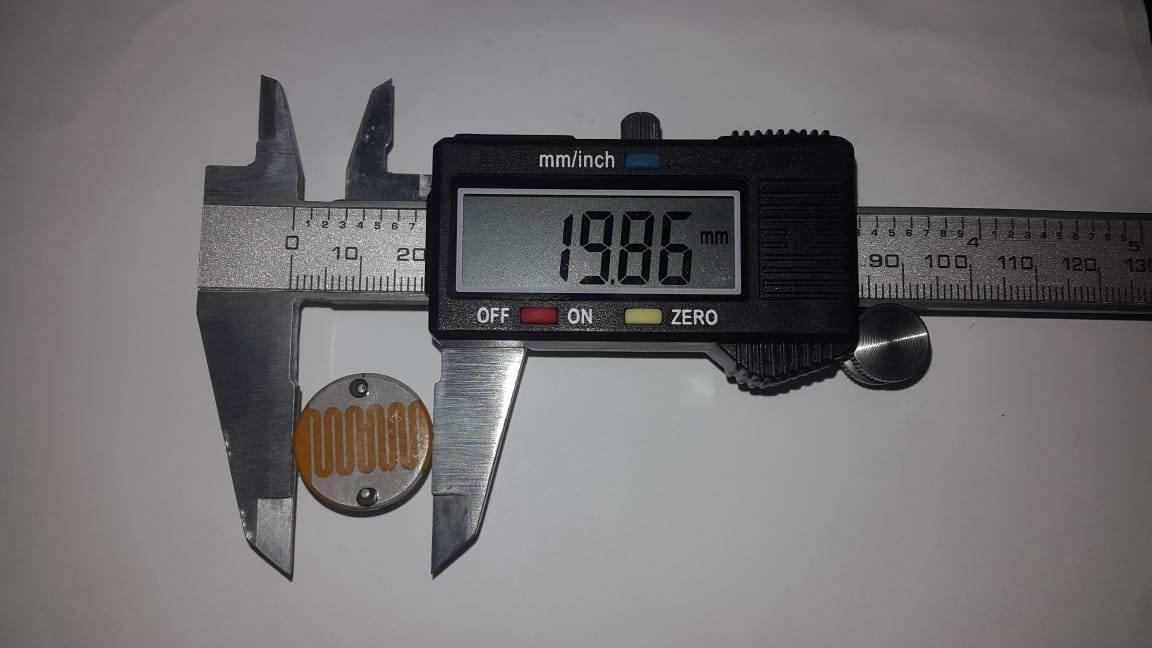 20mm LDR Sensor Light Dependent Resistor Sensor - being measured by a digital caliper showing a reading of 19.86 mm on its display.