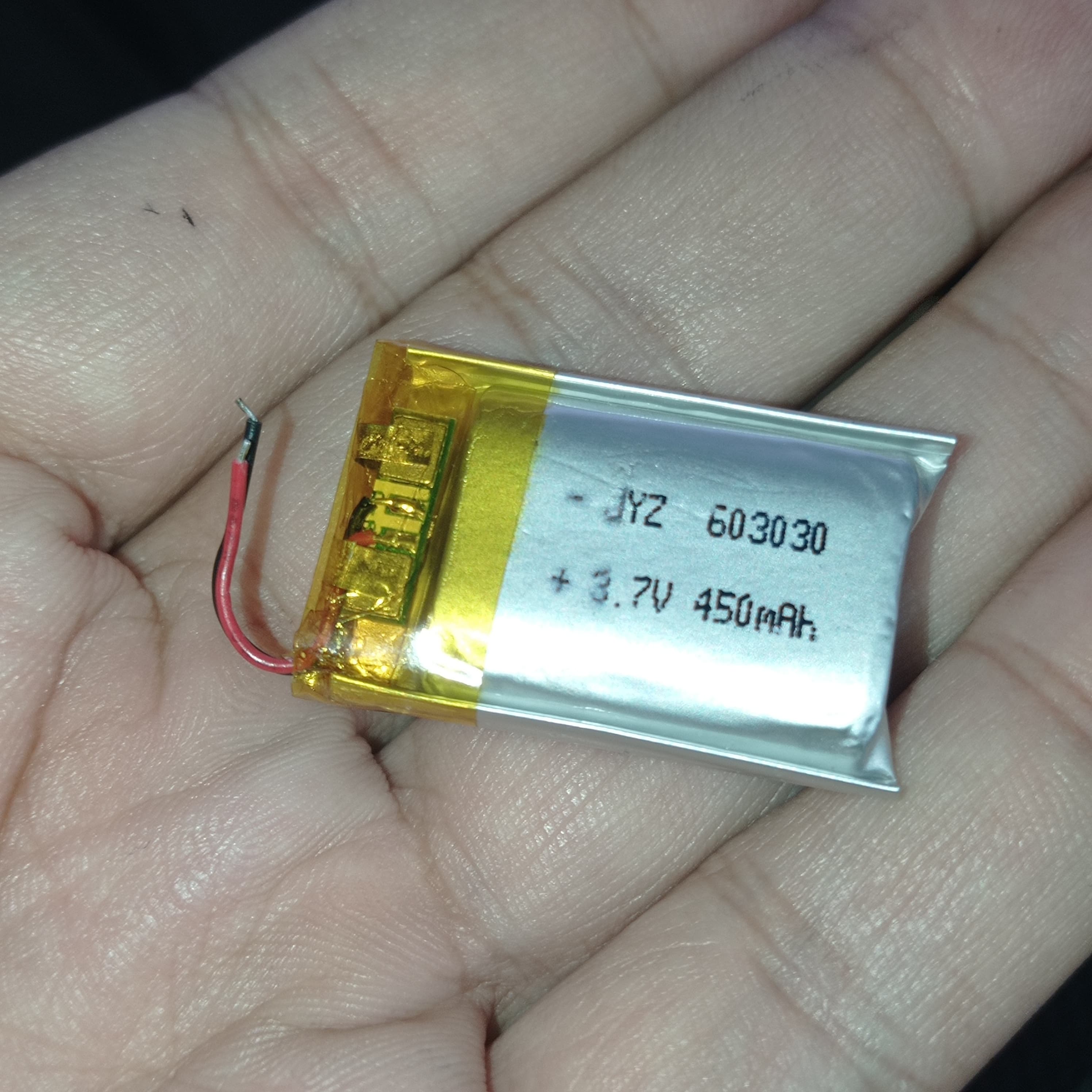 20mm x 30mm x 8mm 3.7V 450mA Li Ion Battery - a small rectangular silver pouch cell with yellow tape, two wires, and text reading JYZ 603030, held in a hand.