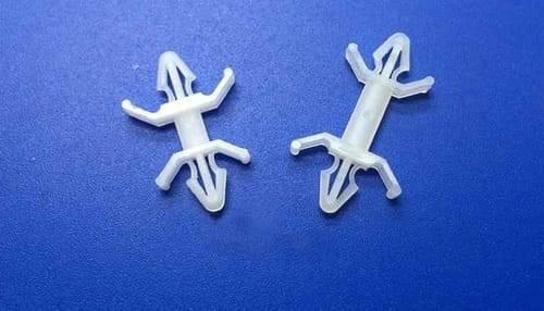 20mm Xlb Nylon PCB Board Rivet Spacer - two white plastic fasteners with barbed ends and side wings against a blue background.