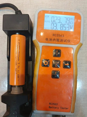 21700 3.7V 3000mA Lithium Ion Cell - 3000mAh Lithium Ion Cell in a black battery holder next to an RC3563 battery tester showing 23.79mΩ and 3.853V on its digital display.
