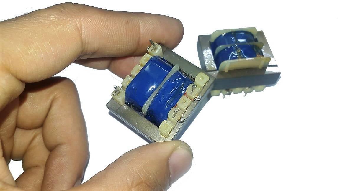 220V To 6V Step Down Transformer - shown as two small electronic components with blue-wrapped coils and metal frames held by a hand.
