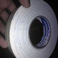 24mm Double Sided Adhesive Tape - a roll of white foam tape with blue printed branding on the side and a central paper core.