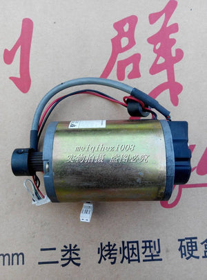 24V Japan Yaskawa Servo DC Motor With Encoder Ugfmed-03SRI11 0V To 27V Maximum - a cylindrical gold-toned motor with a black gear, attached wiring, and white connectors.