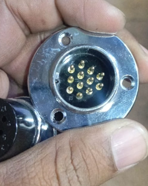 25mm 12 Pin Connector - a close-up view of a silver-colored circular chassis mount connector with twelve gold-plated male pins inside a black insert.