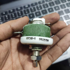 25W 1k Ohm High Power Wire Wound Potentiometer, Rheostat, Variable Resistor - shown as a green cylindrical component with a metal shaft and mounting nut held in a hand.
