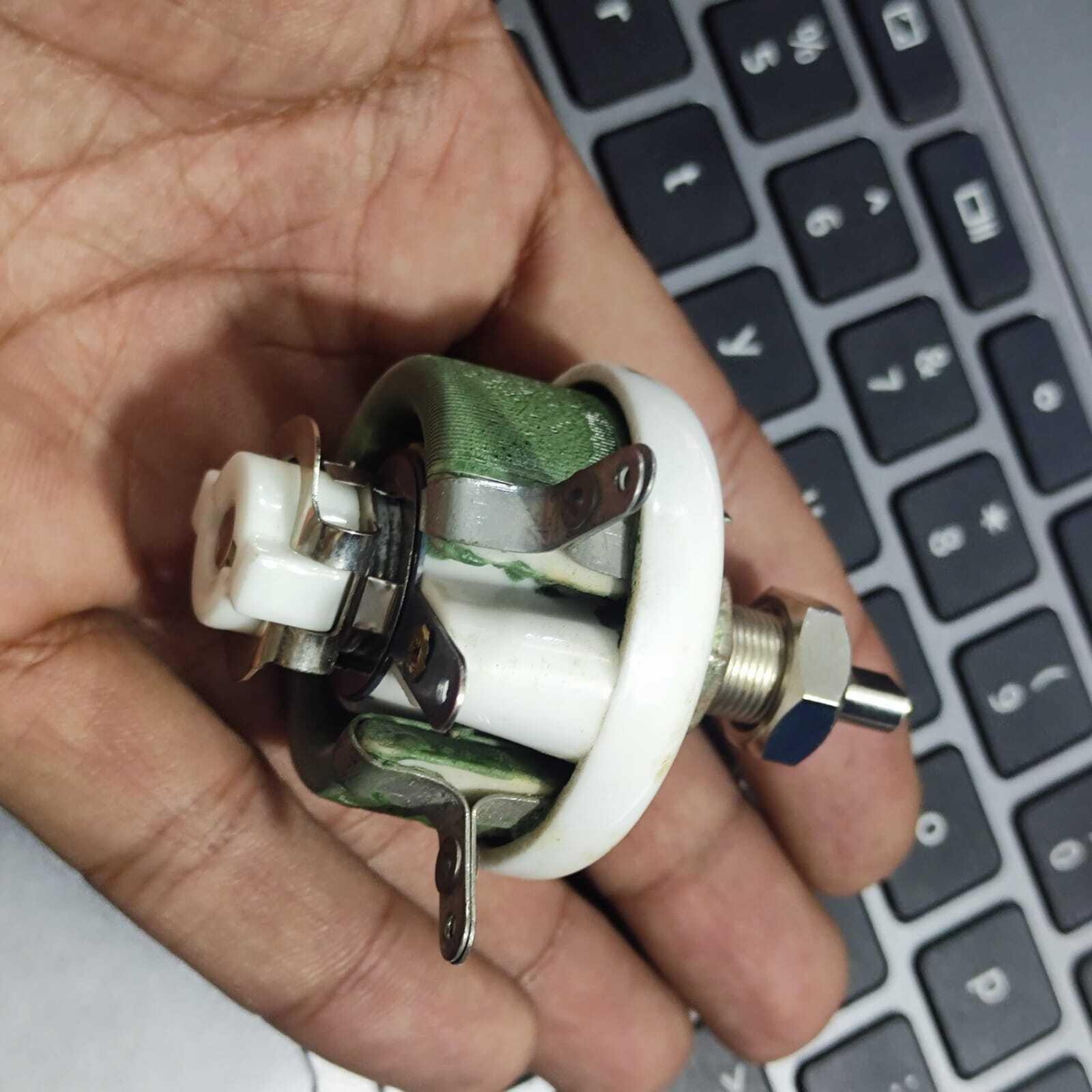 25W 1k Ohm High Power Wire Wound Potentiometer, Rheostat, Variable Resistor - shown in a close-up held by a hand, featuring a green ceramic body and metal terminals.
