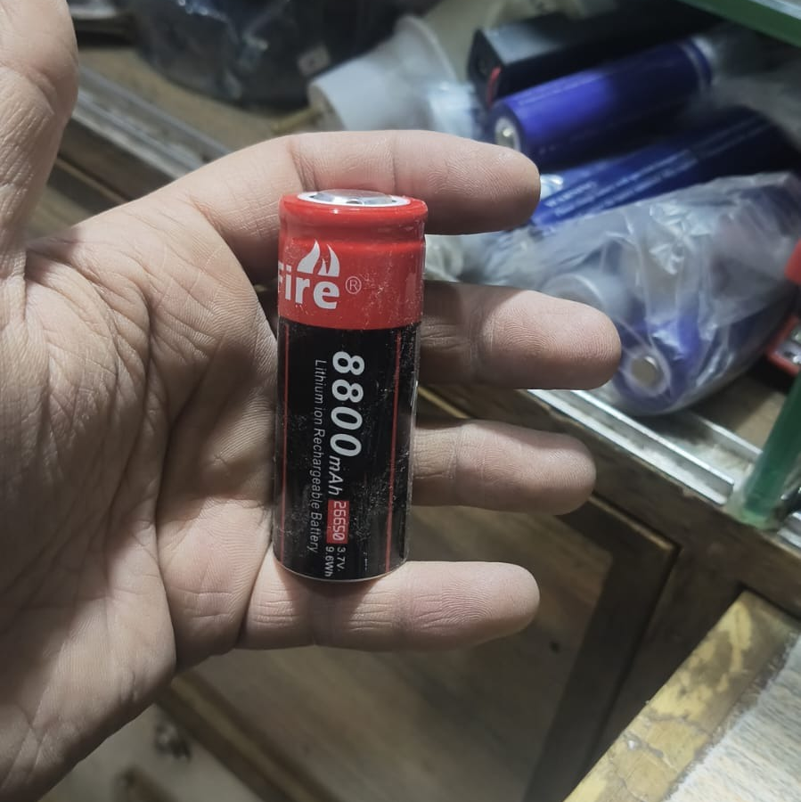 26650 Rechargeable Li-ion Battery Cell 4000mAh - held in a hand, showing a black and red cylindrical casing with printed text including 8800mAh and 26650.