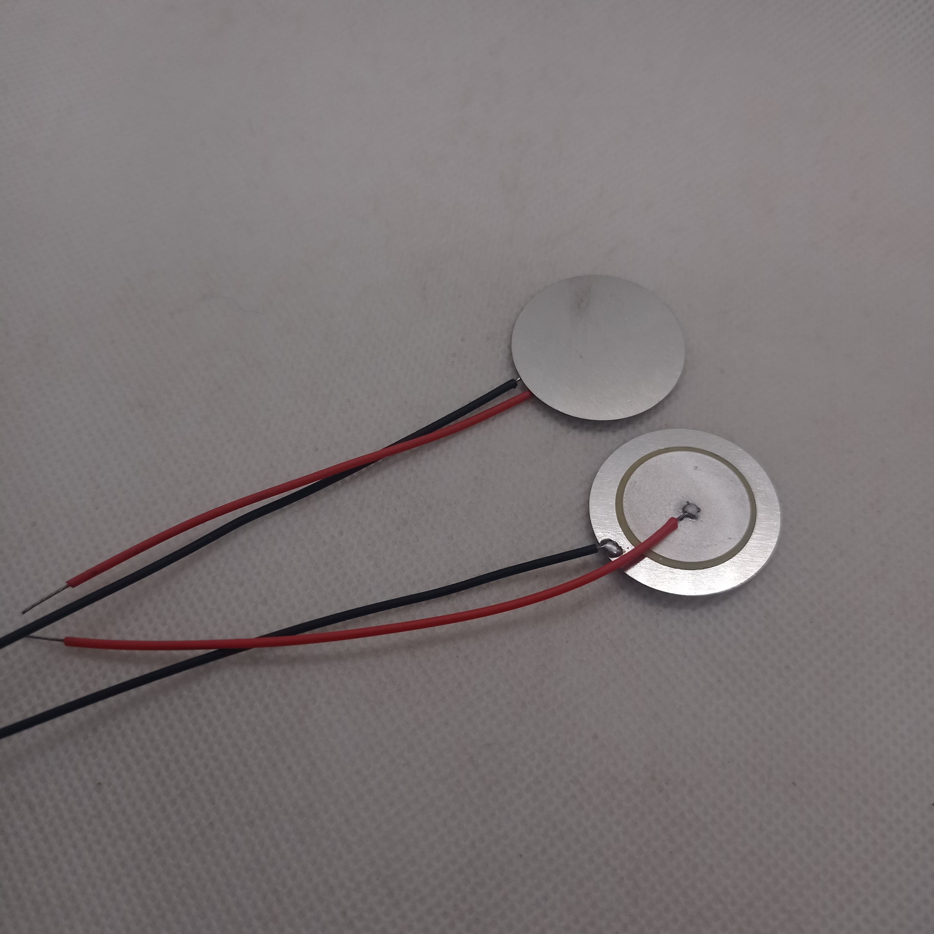 27mm Piezoelectric Ceramic Disc Piezo Element Plate With Wires - two circular silver-colored discs with attached red and black wires.