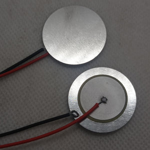 27mm Piezoelectric Ceramic Disc Piezo Element Plate With Wires - two silver circular discs with red and black wires soldered to their surfaces.