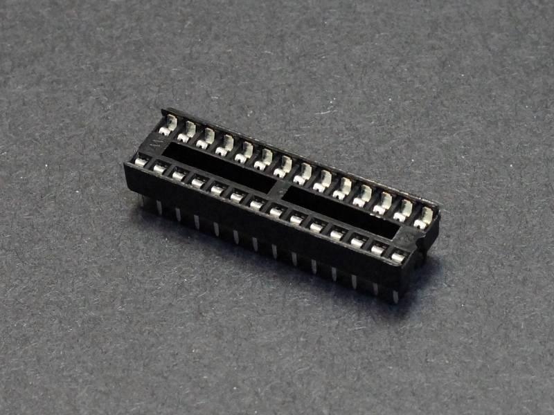 28 Pin DIP IC Socket Base Adaptor Connector - shown as a black, rectangular plastic component with two rows of metal pins on a dark grey background.