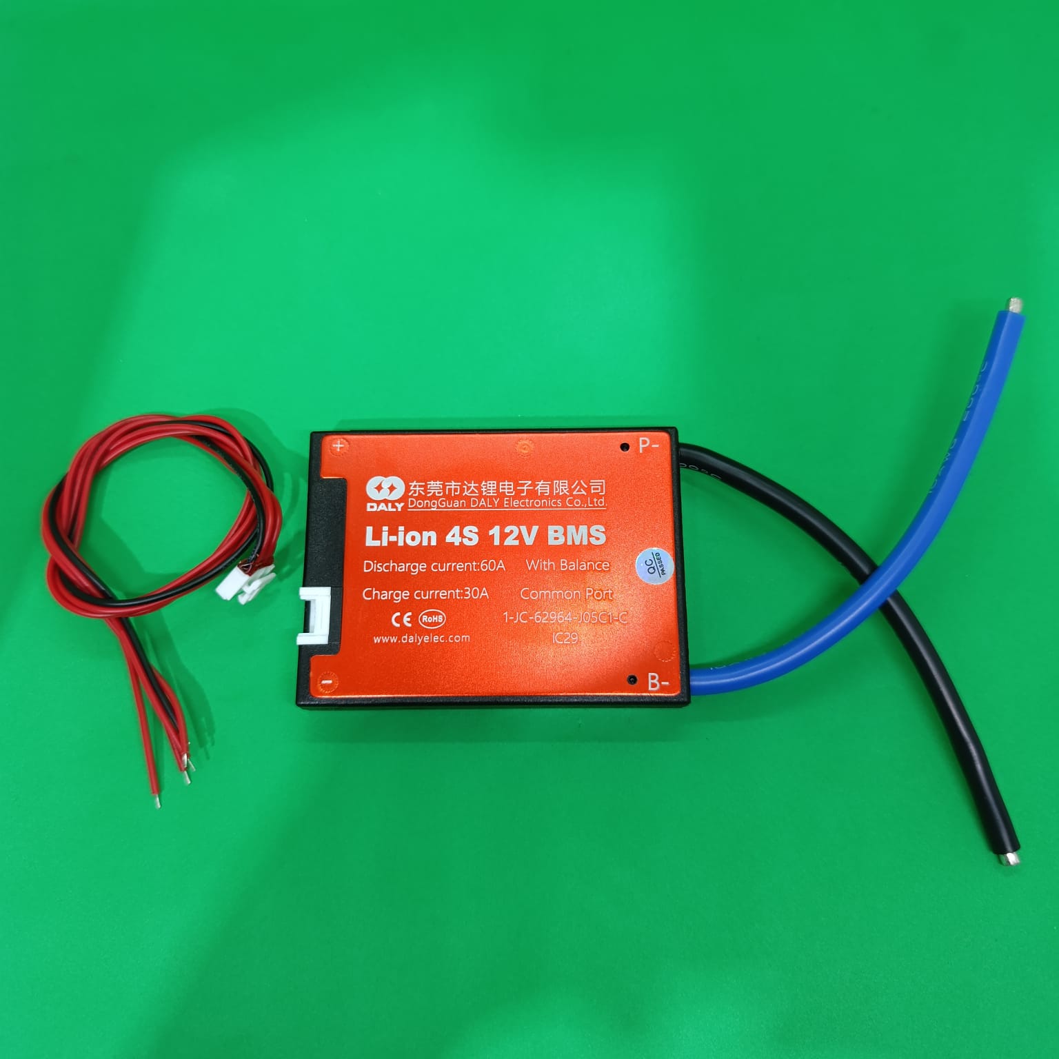 3.2V Daly BMS LiFePO4 4s 12V 60A PCB Protection Board With Common Connection Lithium Batteries With 3.2V DIY Power Tools - red casing, black and blue wires, and a red balance connector cable on a green background.
