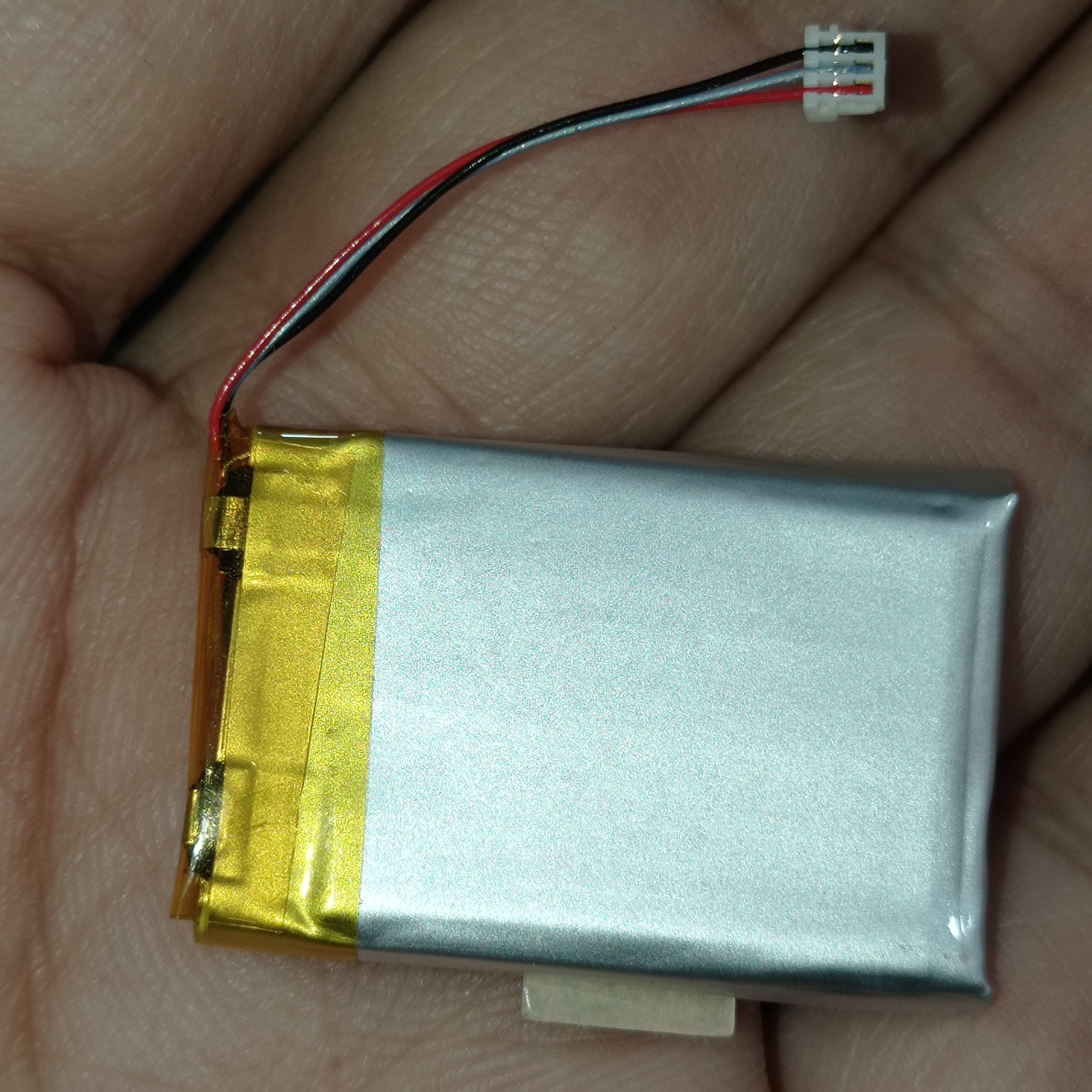 3.7V 100mAh Lithium-ion Polymer Battery - High Energy, Compact Power Source - a silver rectangular battery with yellow tape, connected to a small white three-pin electrical connector.