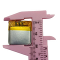 3.7V 70mAh Lithium Ion Li-ion Battery - shown in a close-up view being measured by pink plastic calipers.