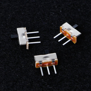 3 Pin 8.5mm Mini Vertical Spdt Slide Switch Toggle Switch - three small metal-cased switches with black sliding toggles and three pins each on a black surface.