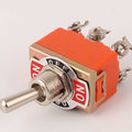 3 Position On Off On Screw Terminal Toggle Switch 6 Pin Pakistan - an orange toggle switch with a metal lever, a mounting plate labeled ON-OFF-ON, and six screws.