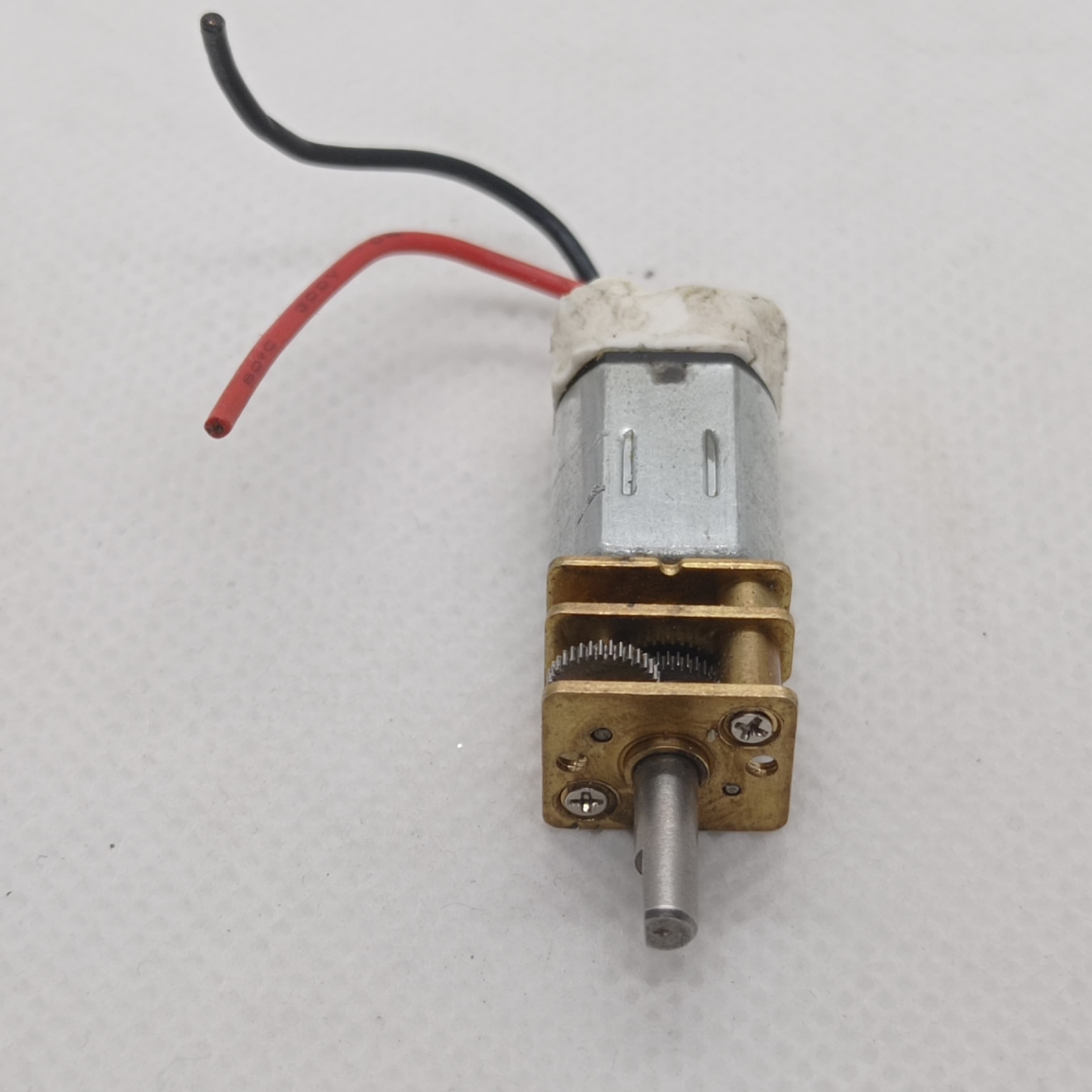 300RPM N20 DC Gear Motor The Perfect Low RPM High Torque Motor For Your Electronics Projects - a silver cylindrical motor attached to a brass gearbox with a metal output shaft and red and black power wires.
