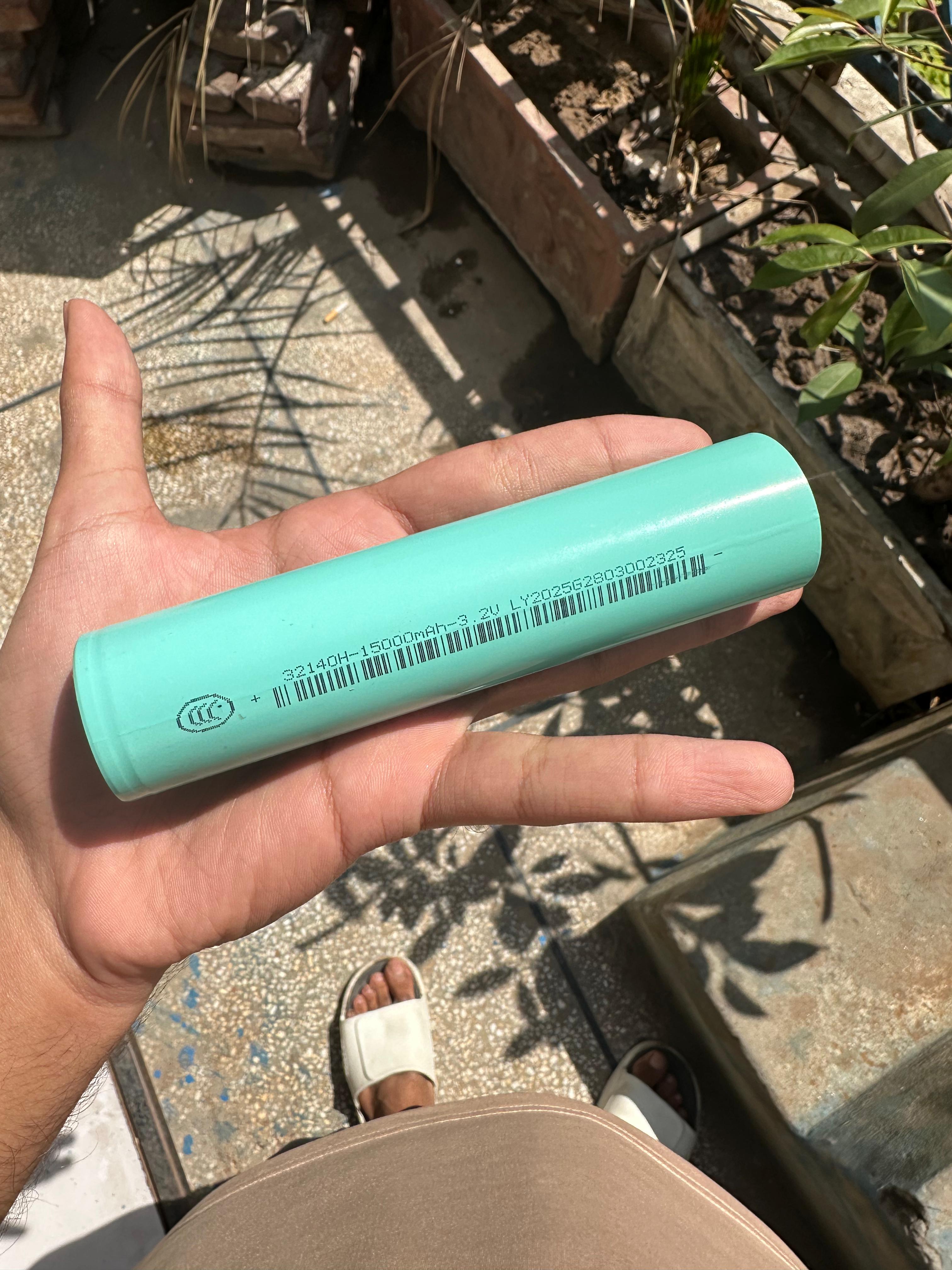 32140 3.2V 15A LiFePO4 Cell - the light green cylindrical body with printed specifications and a barcode.