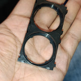 32140 Lithium Cell Holder Bracket - Dual Cell Spacer - a black plastic rectangular frame with two circular cutouts held in a person's palm.