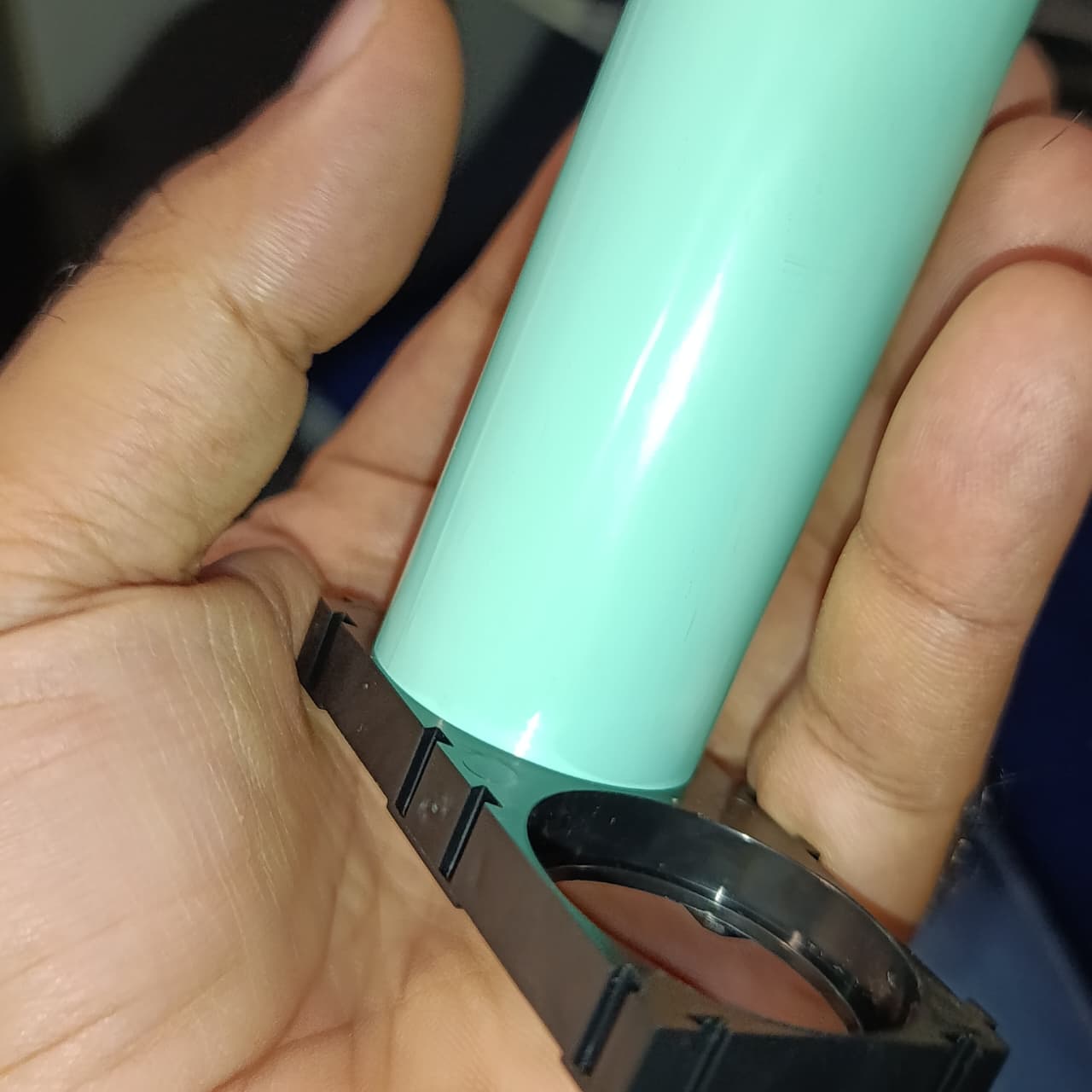 32140 Lithium Cell Holder Bracket - Dual Cell Spacer - shown in a close-up view holding a single light green cylindrical battery cell.
