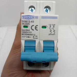 32A Tomzn Tob7z-63 2p DC 1000V Solar Circuit Breaker - Reliable Protection For Solar System - a white two-pole modular device with blue toggle switches, held in a hand against a plain white background.