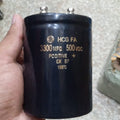 3300µF 500V Electrolytic Capacitor price - a large black cylindrical component held in a hand, featuring two metal terminals on top and printed technical specs.