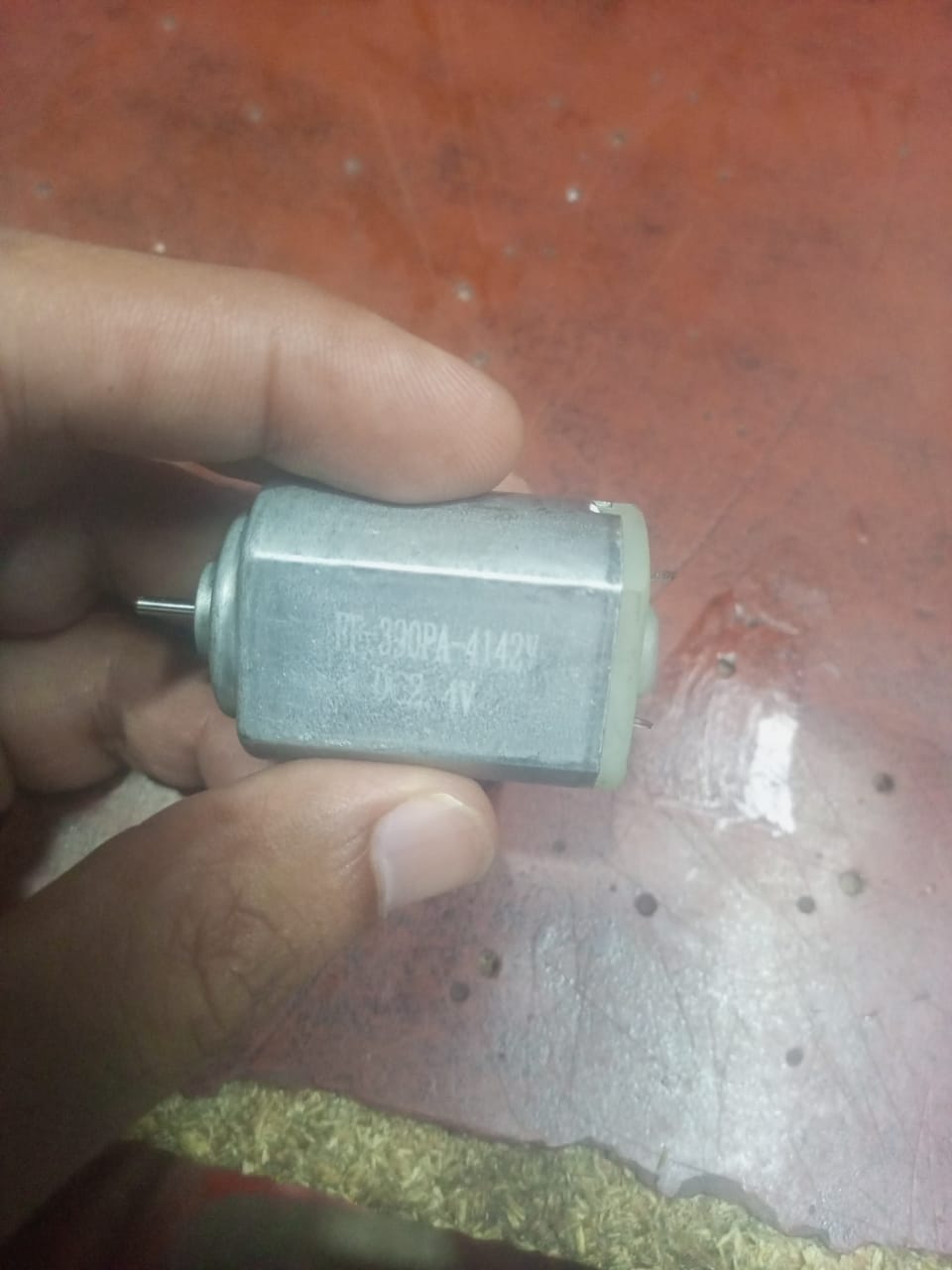 390PA DC Motor - shown in a hand, featuring a silver cylindrical metal body with a small rotating shaft and visible model text printed on the side.