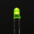 3mm Green LED - a small round green light-emitting diode glowing against a black background with two metal pins extending downward.