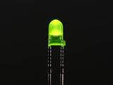 3mm Green LED - a small round green light-emitting diode glowing against a black background with two metal pins extending downward.