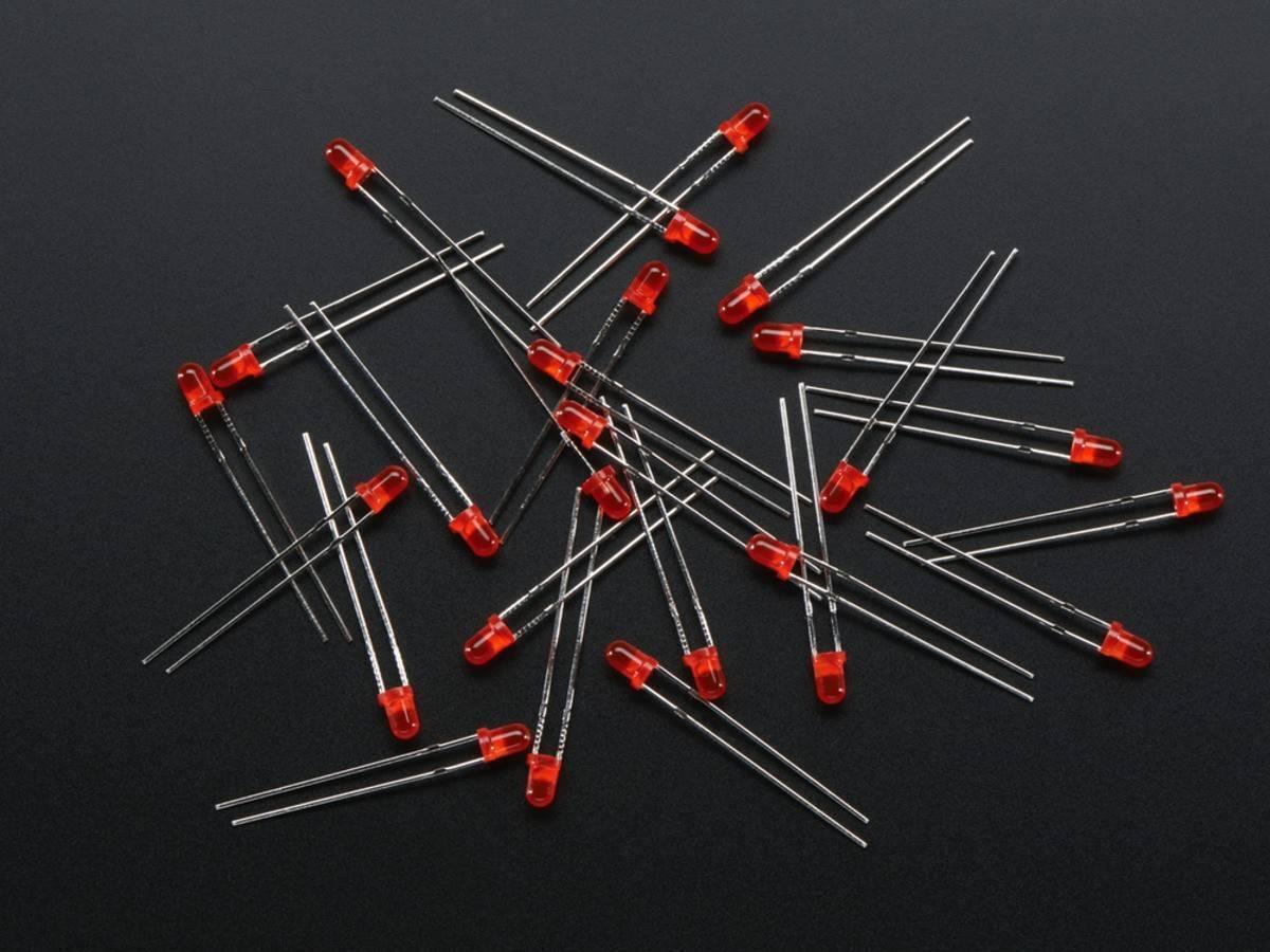 3mm Red LED - a scattered pile of small, round, red-colored light-emitting diodes with two metallic leads each, set against a dark background.