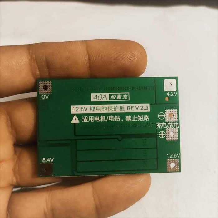 3s 40A BMS 11.1V 12.6V 18650 Lithium Battery Protection Board With 100mA Balancing Feature - a green rectangular circuit board held in a hand with clearly labeled 0V, 4.2V, 8.4V, and 12.6V terminals.