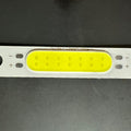3W 3.7V 1000mA 300LM LED COB Light Module - a rectangular white circuit board with a yellow light-emitting strip and marked positive and negative terminals.
