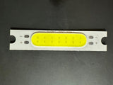 3W 3.7V 1000mA 300LM LED COB Light Module - a rectangular white circuit board with a yellow light-emitting strip and marked positive and negative terminals.