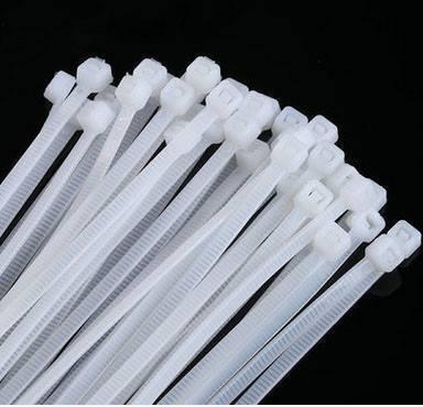4 Inch 100mm PVC Cable Tie - a bundle of white plastic cable ties with locking mechanisms against a black background.