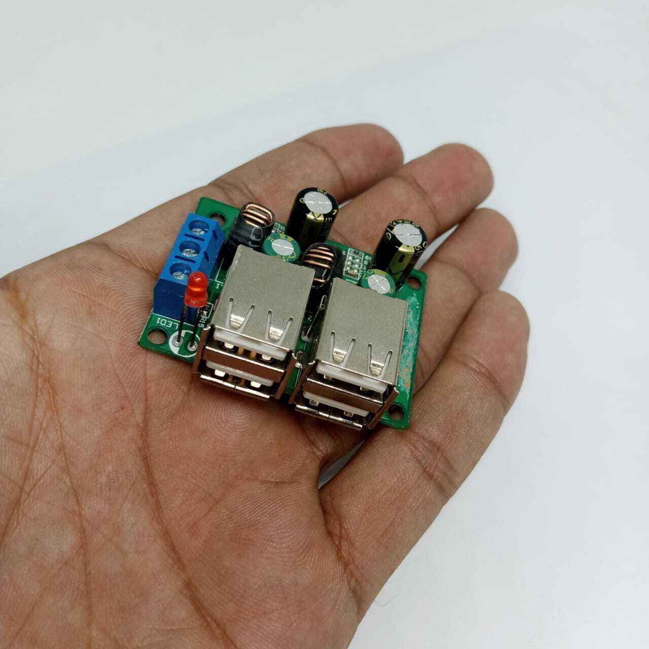 4 USB Port A5268 Chip Step Down Transformer Converter Board Module DC 12V 24V 40V To 5V 5A 25W For MP3/MP4 Phone Car Equipment - held in a hand, featuring two dual USB ports, a blue screw terminal, a red LED, and several capacitors.