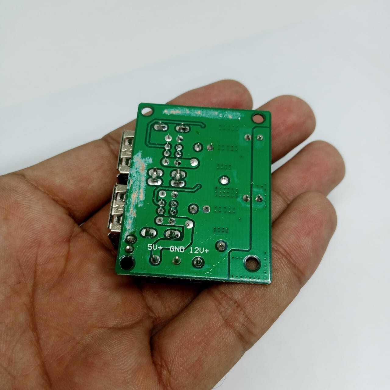4 USB Port A5268 Chip Step Down Transformer Converter Board Module DC 12V 24V 40V To 5V 5A 25W For MP3/MP4 Phone Car Equipment - green circuit board held in a hand showing the underside with 5V, GND, and 12V labeled solder pads.