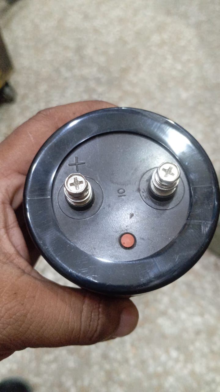 4700uF 500V Electrolytic Capacitor price - a close-up view of the black cylindrical top showing two screw terminals with a plus sign and a red circular vent.