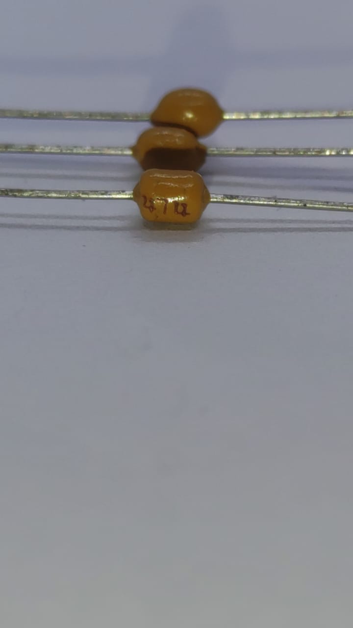 474 Multilayer Ceramic Capacitor resistor type - close-up shot of three small, yellow, axial-leaded components with the text "472" printed on the body.