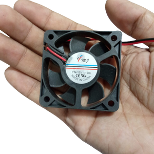48MMX48MMX11MM 12V DC Fan - held in a hand, showing the black square frame, seven-blade impeller, and a label with FW-12V DC text and two power wires.