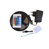 5 Meter 12V RGB LED Light Strip Set - a coiled LED strip, a remote control with color buttons, a white controller box, and a black power adapter.