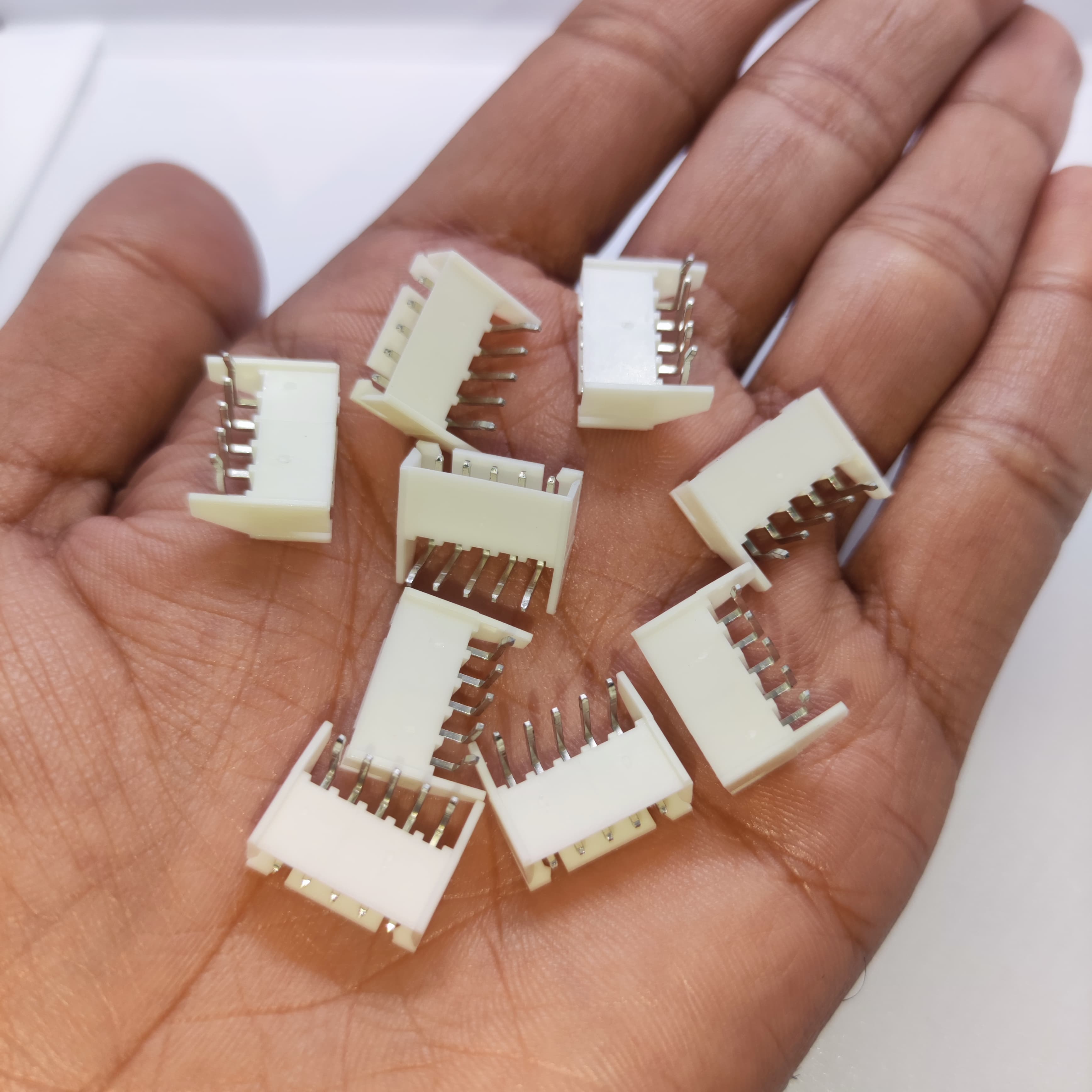 5 Pin Right Angle Male 2.5mm JST Xh Style PCB Mount Connector - shown as a collection of white plastic connectors held in a person's hand.
