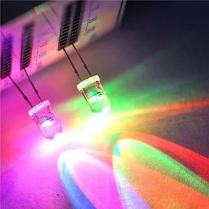 5mm 7 Color RGB Automatic Rainbow Fast Flash LED - shown as two glowing, multi-coloured light-emitting diodes mounted on a white grid-patterned board.