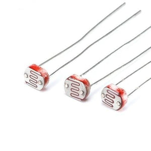 5mm Light Dependent Resistor LDR Sensor - a close-up view of three small, circular electronic components with red, wavy, light-sensitive patterns.