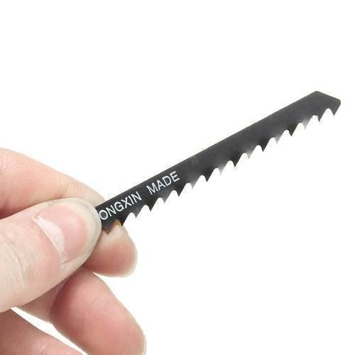 5pcs Jigsaw Blades Wood Cutter T144D - a close-up of a single black metal jigsaw blade with teeth held in a hand.