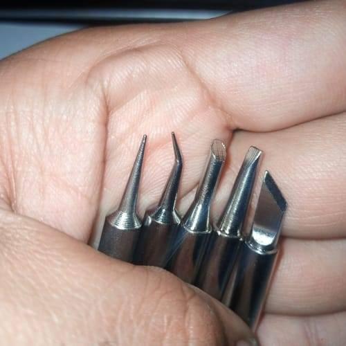 5pcs Lead-free Soldering Iron Tips - a close-up showing five different silver-colored metal soldering tips held in a hand.