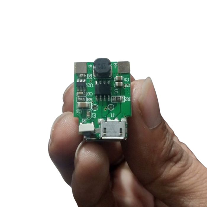 5V 1A power bank module - a small green circuit board held in hand featuring a micro-USB port, a push button, and an inductor coil.