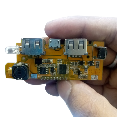 5V 2A DIY Power Bank Module With Display And Emergency Light Points - held in a hand, showing a yellow circuit board with two USB ports, a micro-USB port.