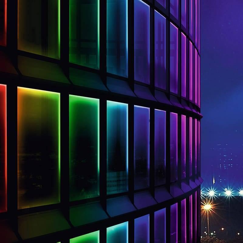 5V 5 Meter Addressable LED Strip WS2812B 30 LED Per Meter - installed along the edges of building windows, displaying a vibrant multicolored gradient.