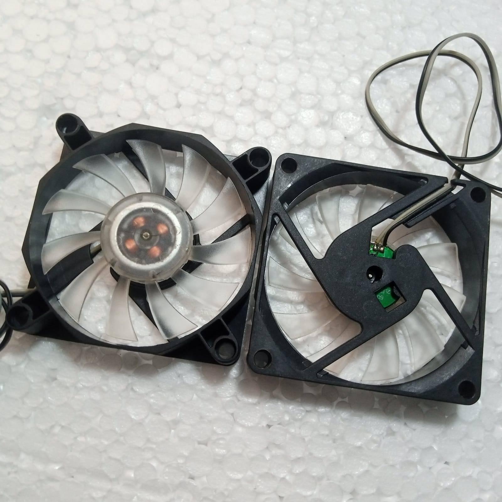 5V Fan With LED - two black square cooling fans with translucent blades and attached wires, viewed from the front and back.